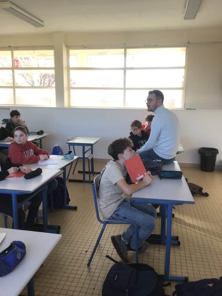 Des élèves dans une salle de classe en discussion avec un monsieur