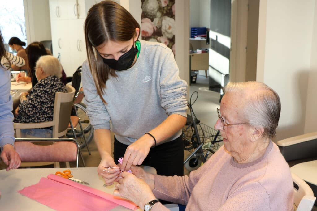 une élève aide une personne âgée